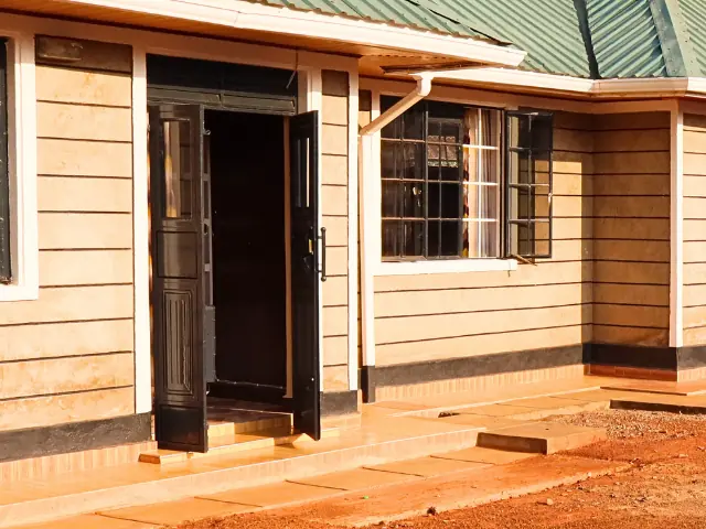 Front of a bungalow with its double doors open onto a tiled step